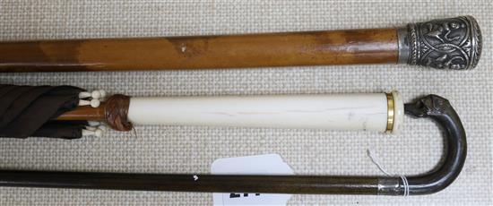 An Indian silver topped malacca cane, a horn dogs head stick and an ivory handled umbrella